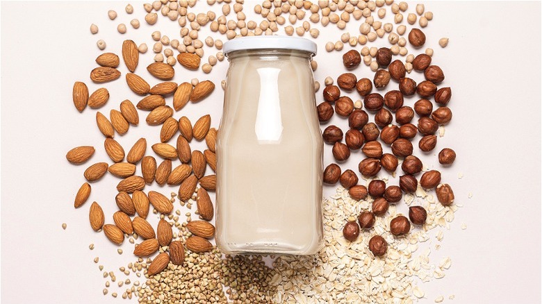 Jar of plant milk next to nuts 