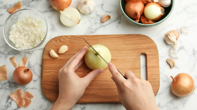 Cutting an onion on a wooden board