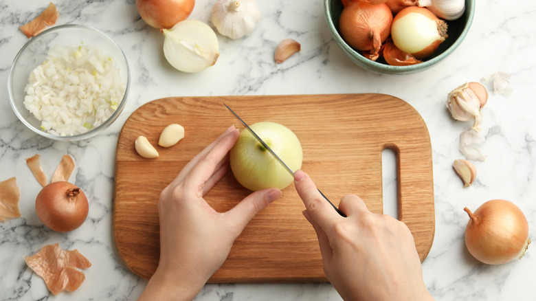 Cutting an onion on a wooden board