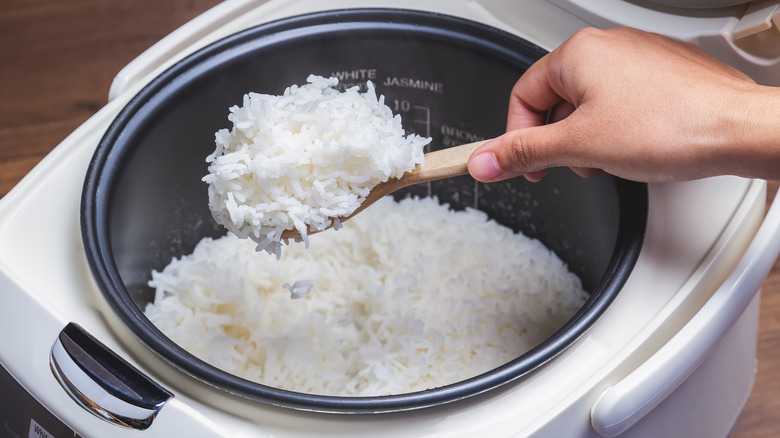 scooping white rice from pot