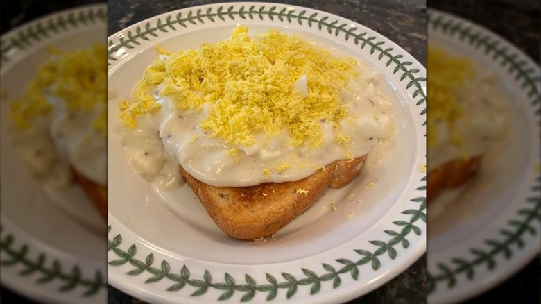 Eggs a la Goldenrod on a while plate with a leaf border