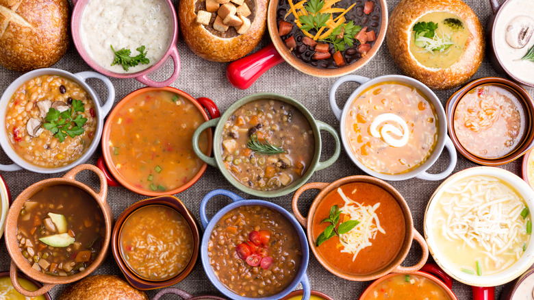Overhead view of different soups in bowls.