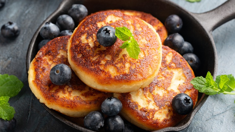 pancakes topped with blueberries in cast iron pan