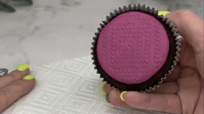 A cupcake with paper towel print pressed into the frosting