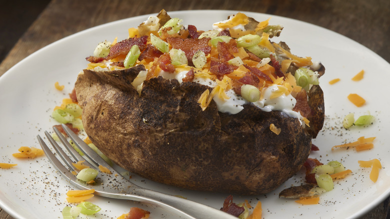 Baked potato on a plate with a fork