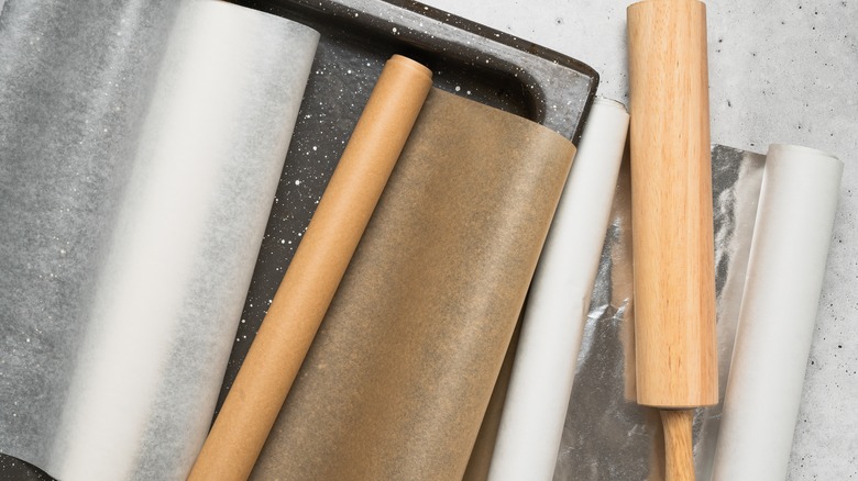 Rolls of parchment paper with kitchen tools
