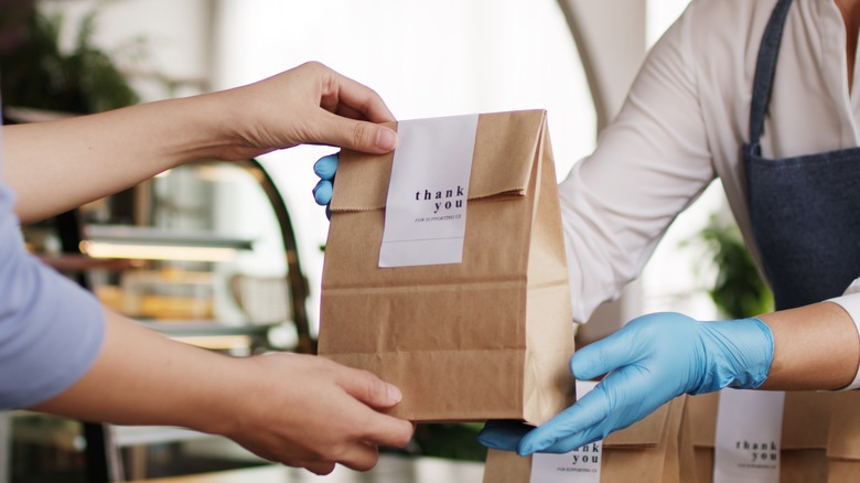 customer taking a bag from a cashier after purchase