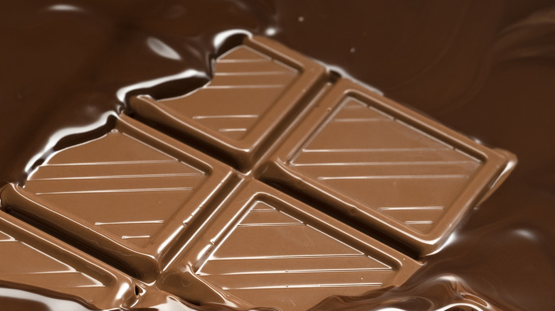 bar of chocolate surrounded by melted chocolate