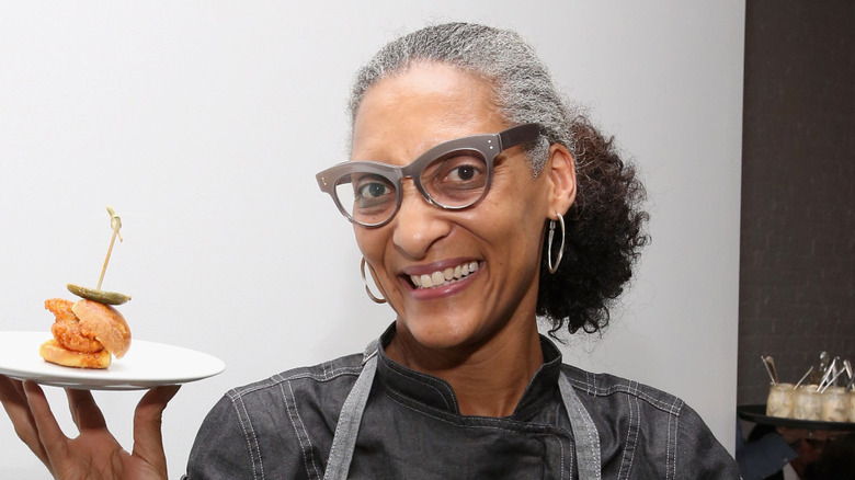 Close up of Carla Hall smiling holding plate