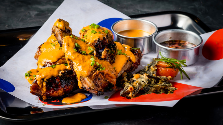 Grilled chicken wings covered in an orange piri piri sauce with green onions