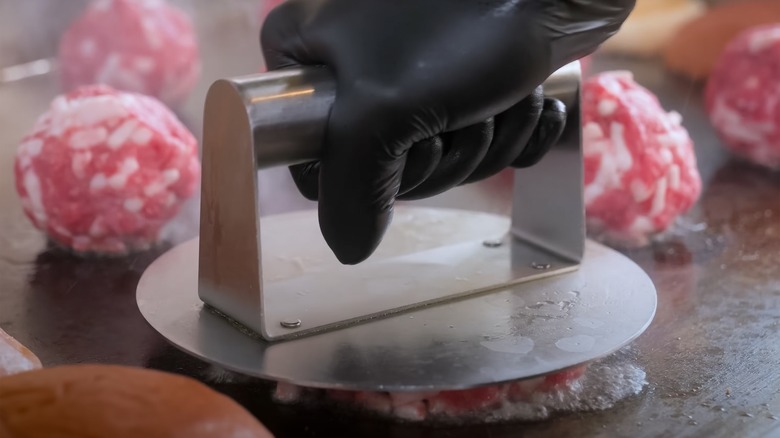 Closeup of meat press on a grill