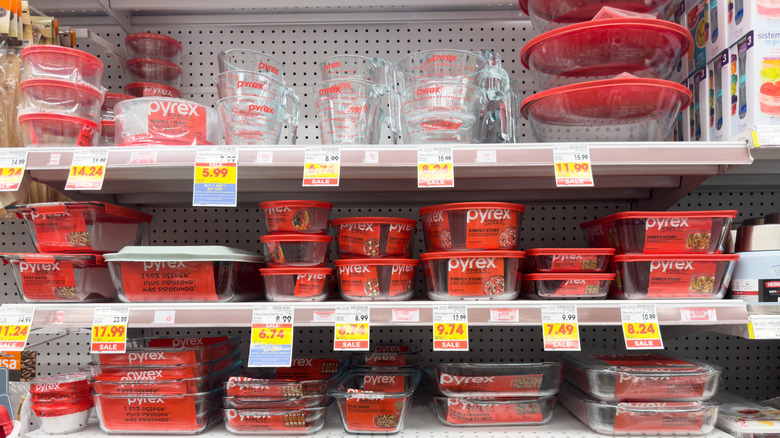 Several shelves full of red Pyrex kitchen products in a store