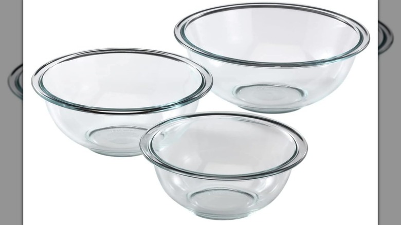 Three transparent Pyrex Essentials mixing bowls on a white background