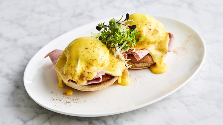 Eggs Benedict with Hollandaise sauce on a plate