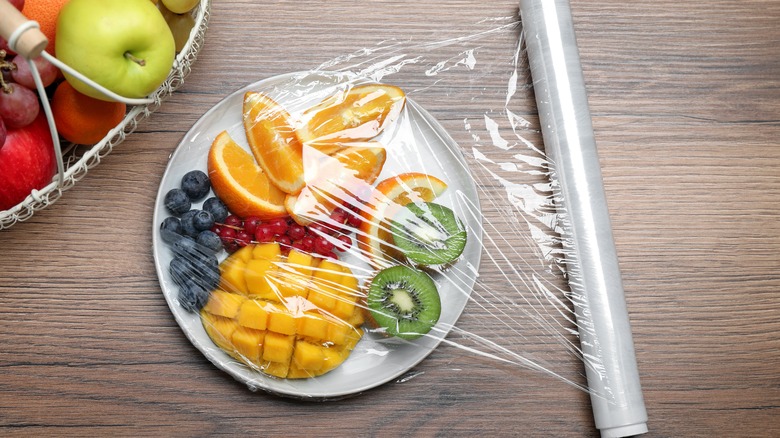Plate of fruit with plastic wrap