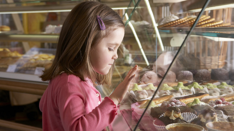 Child staring into bakery display case