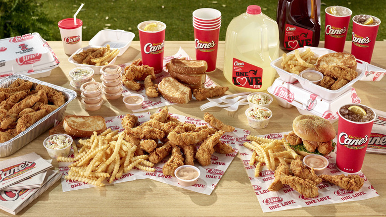 Raising Cane's food on picnic table with drinks