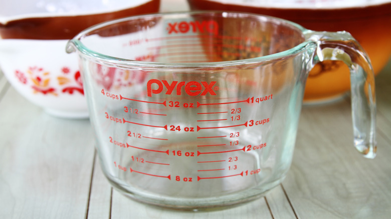 Pyrex glass measuring cup with stacks of bowls in the background