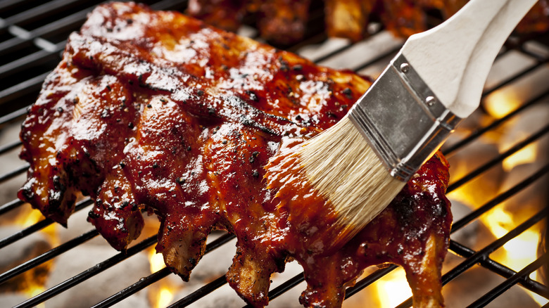 Brush basting ribs with sauce