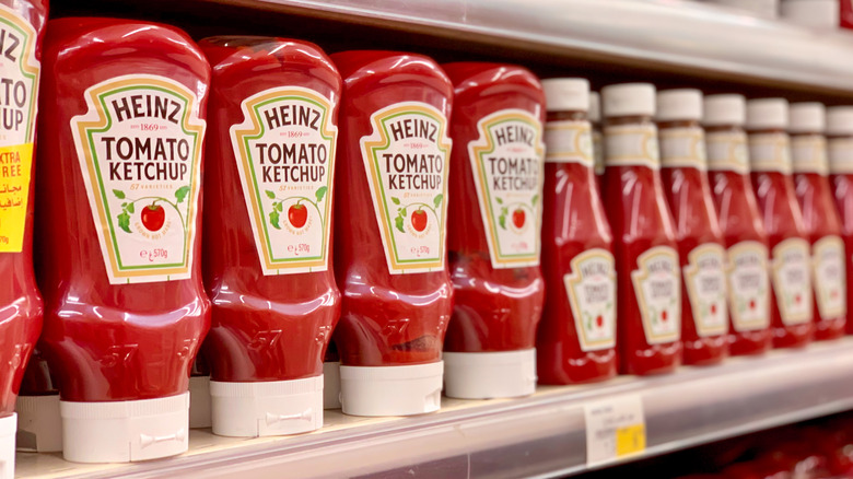 Heinz ketchup bottles lining grocery shelf