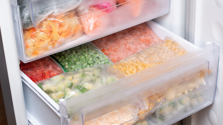 Frozen vegetables in plastic bags in freezer