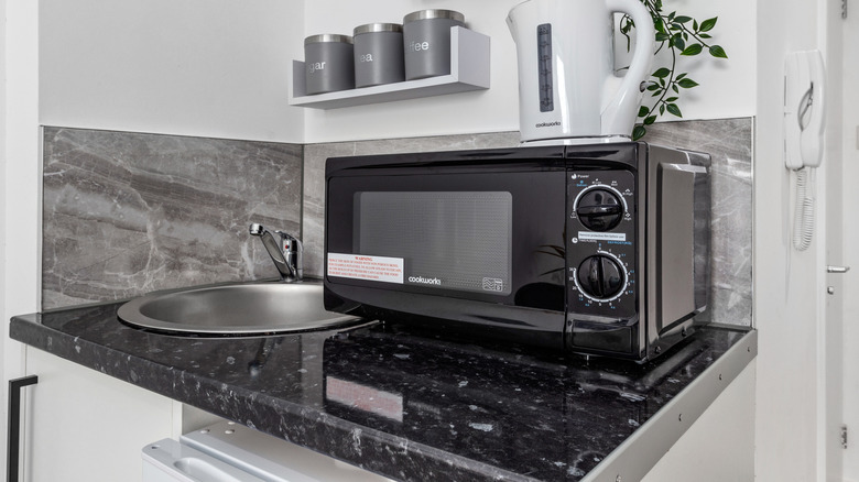 A countertop microwave on a black countertop
