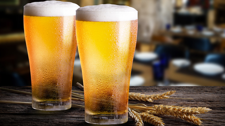 Two foamy headed beers on bar