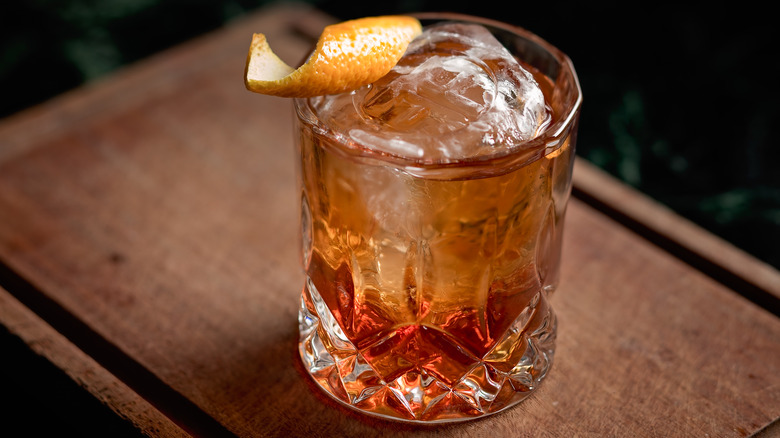 Old Fashioned cocktail garnished with orange rind 