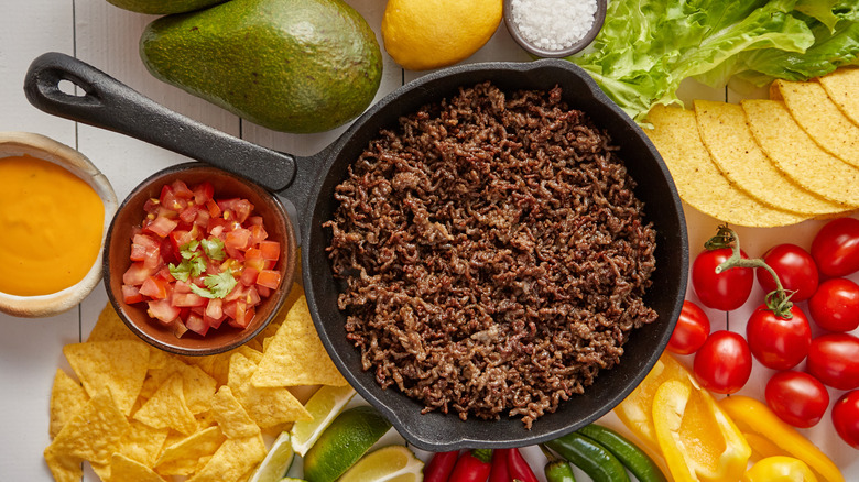Taco meat in pan with toppings