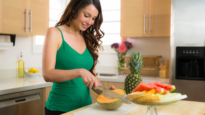 Woman cutting a cantaloupe 
