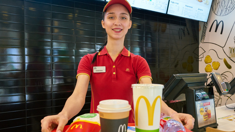 McDonalds employee holding tray of food