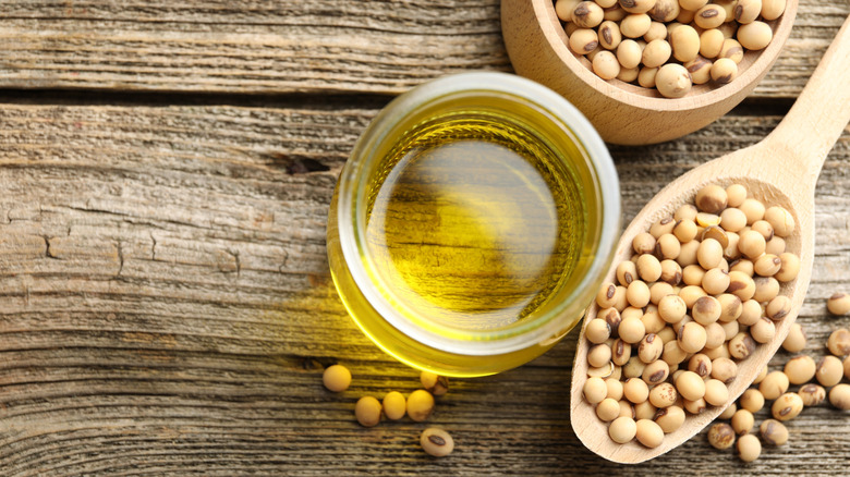 Cooking oil and soybeans on wooden table