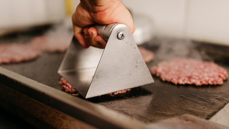 smash burgers pressed on griddle