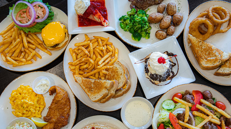 Assorted plates of diner food on table.