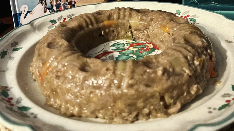 A jellied meatloaf molding from a bunt pan on a decorative plate