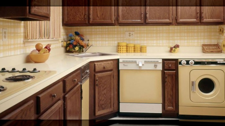 A kitchen with yellow wallpaper and Harvest Gold appliances