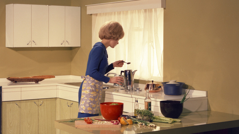 Woman cooking in 1960s kitchen