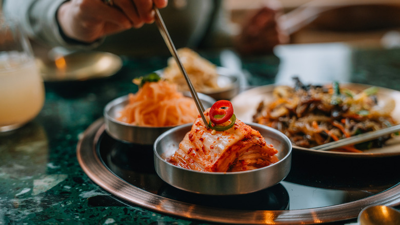 Hand picking up kimchi with chopsticks