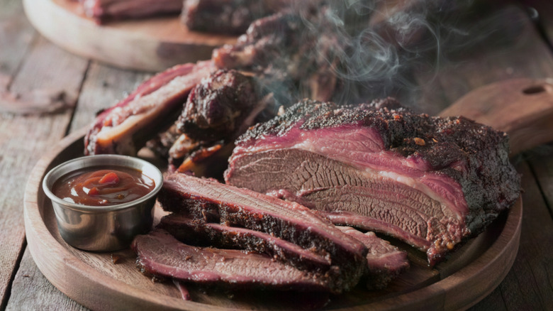 Platter of smoked brisket and ribs with sauce on the side