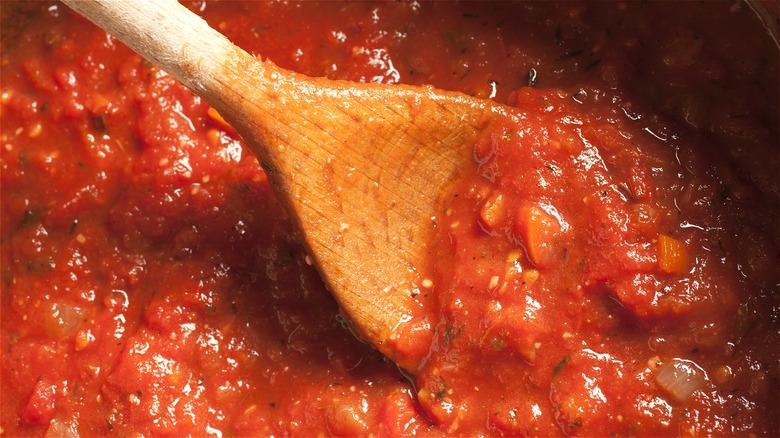 Wooden spoon in tomato sauce 