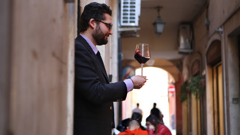 A man swirls a glass of wine
