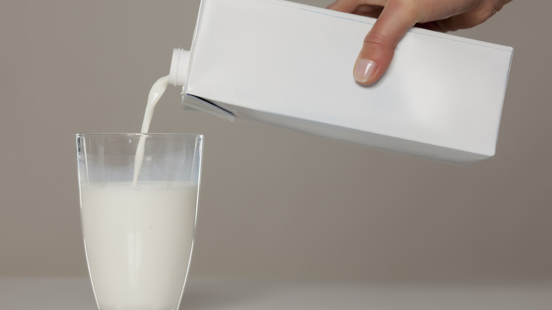 Hand pouring milk into glass