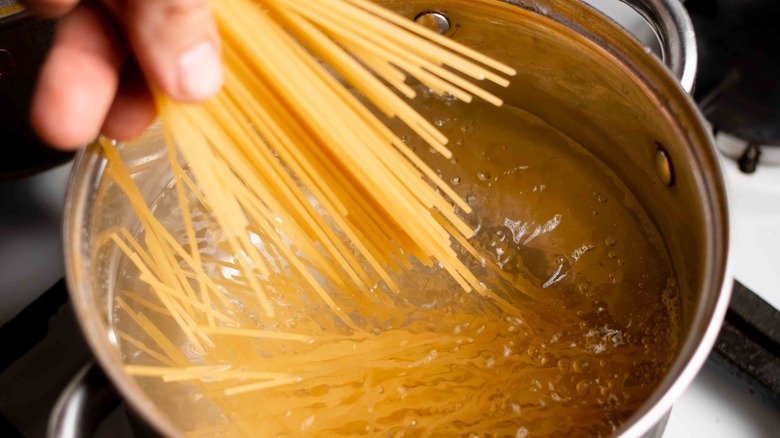 Adding pasta noodles to boiling water