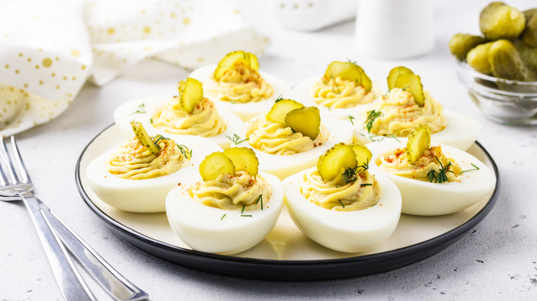 Deviled eggs topped with pickles