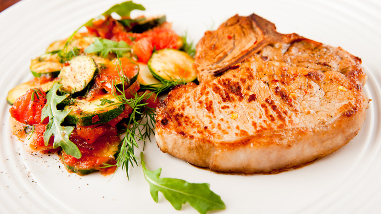 pan-fried pork chop on a plate with salad