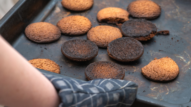 taking partially burnt cookies out of oven