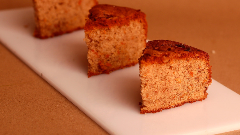 Three small slices of simple uniced cake on a white board
