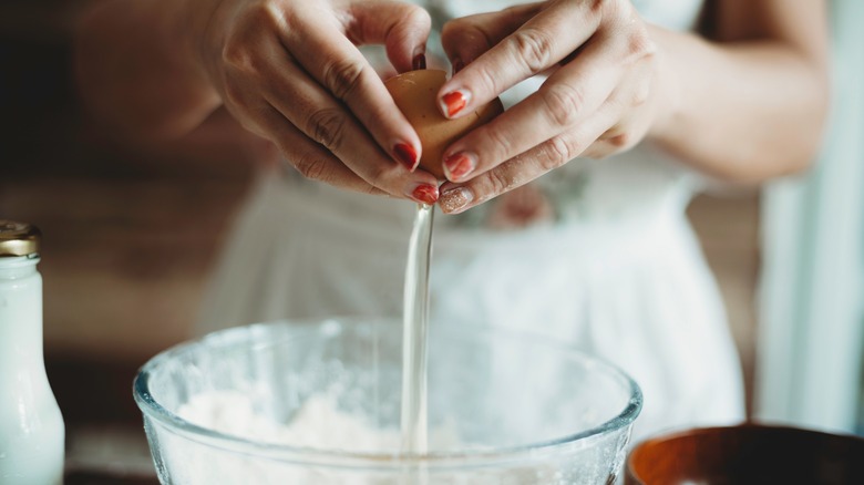 cracking an egg into mixing bowl