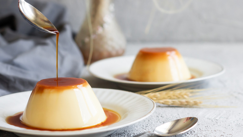 Two flans with spoon pouring caramel