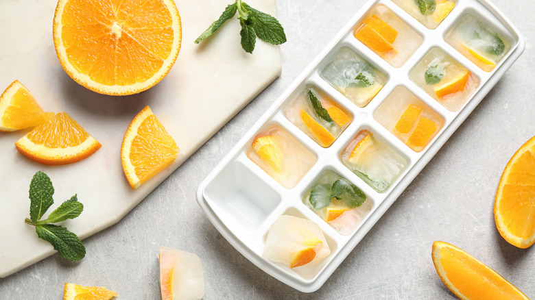 Orange and mint pieces frozen in cube cube tray